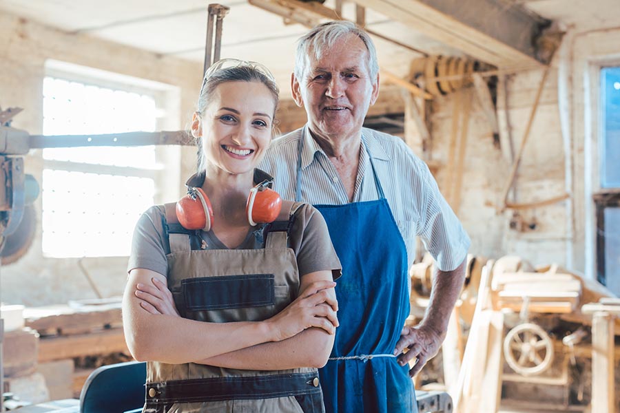 Business Insurance - Father and Daughter Stand in the Workshop of Their Carpentry Business, Wearing Protective Equipment